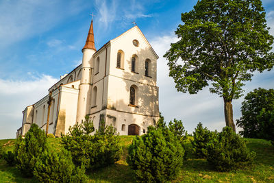 A small church in the middle of the lush green spring landscape on a sunny day. church in lithuanua.