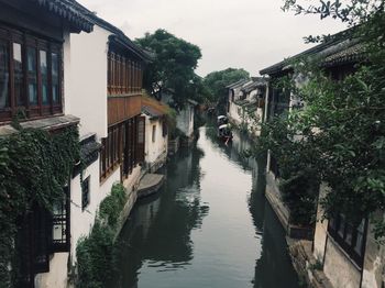 Canal amidst buildings against sky