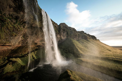 Scenic view of waterfall against sky