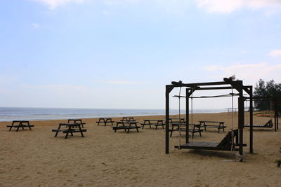 Playground on beach against sky