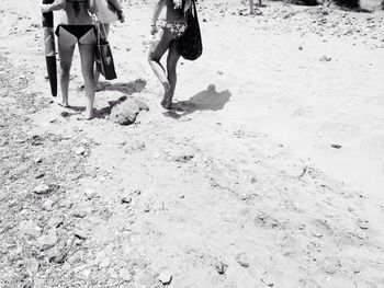 Low section of women standing on beach