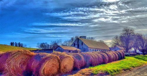 Hay bales on field against sky