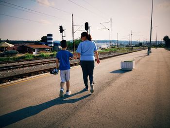 Rear view of people walking on road in city