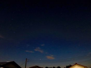 Low angle view of silhouette cables against sky at night