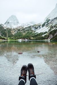 Low section of man on rock by lake