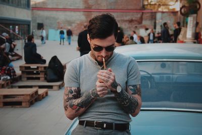 Man lighting cigarette on street