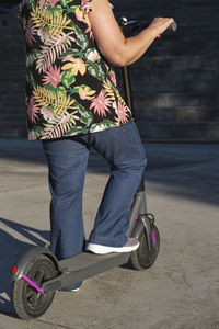 Low section of woman on electric push scooter