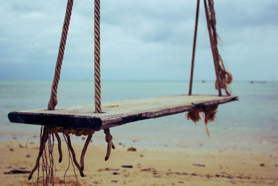 Close-up of rope on beach against sky