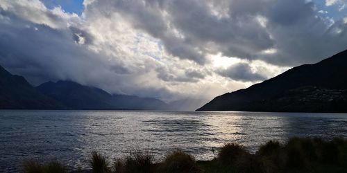 Scenic view of sea and mountains against sky