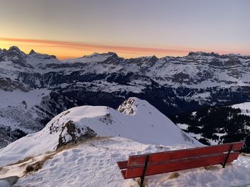 Scenic view of snow covered mountains against sky during sunset