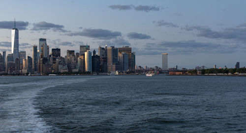 Lower manhattan skyline at sunset viewed from the water.