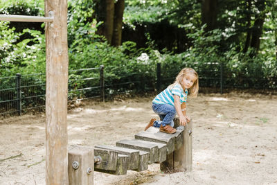 Full length of girl standing on outdoor play equipment in park