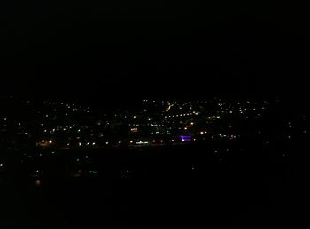 Illuminated cityscape against sky at night