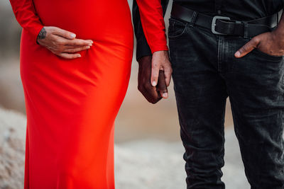 Midsection of man with hands standing outdoors