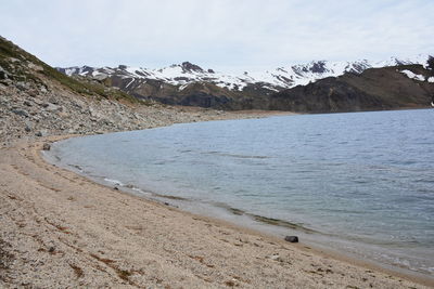 Scenic view of snowcapped mountains by sea against sky