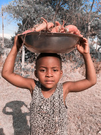 Little african girl carrying sweet potatoes