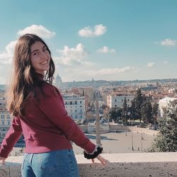 Portrait of young woman standing against sky in rome