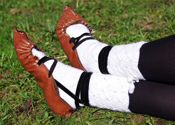 Cropped image of person holding drinking straw over plant on field