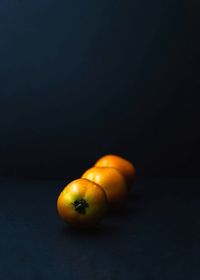Close-up of orange on table against black background