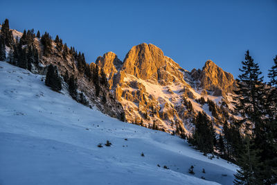 Panoramic view of snowcapped mountains against clear blue sky