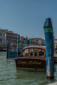 Boat in canal against clear blue sky