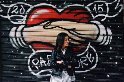 Full length of man standing on graffiti wall