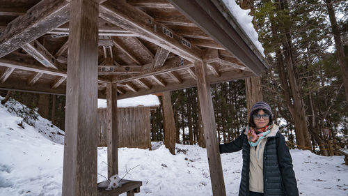 Portrait of smiling woman standing on snow covered field