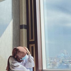 Portrait of woman standing by window