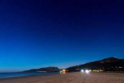 Scenic view of sea against clear blue sky at night