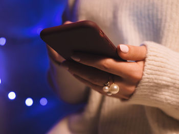 Midsection of woman holding smart phone