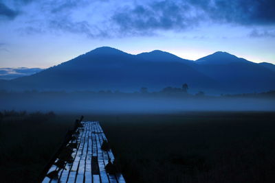 Scenic view of land and mountains against sky