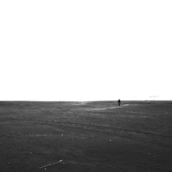 Man standing on beach against clear sky