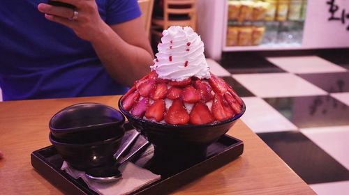 Close-up of person holding ice cream on table