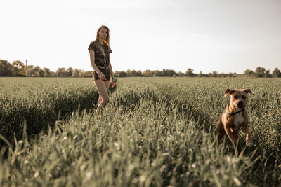 Young woman with dog on agricultural field