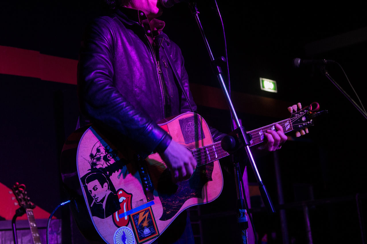 MAN PLAYING GUITAR AT NIGHT