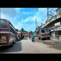 Cars on road against cloudy sky