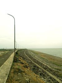 Road by sea against clear sky