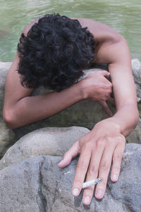 Midsection of woman sitting on rock