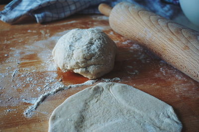 Close-up of kneaded dough by rolling pin on table