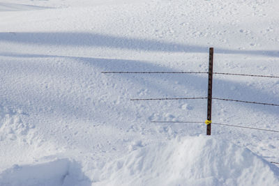 Fence buried in a snow drift.