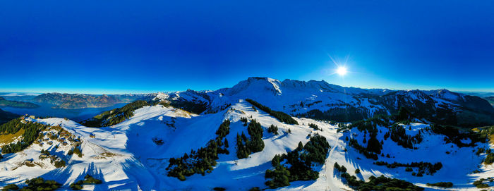 Scenic view of snowcapped mountains against blue sky