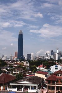 Buildings in city against cloudy sky