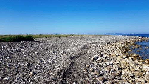 Surface level of road against clear blue sky