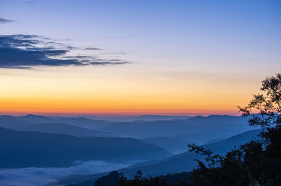 Scenic view of silhouette mountains against sky at sunset