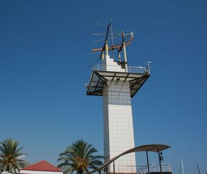 Low angle view of communication tower against clear blue sky