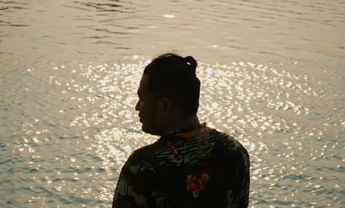 Rear view of man standing at beach