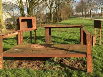 Empty bench on grassy field in park