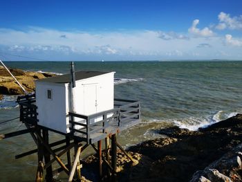 Lifeguard hut on beach against sky