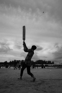 Full length of man playing cricket on beach