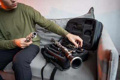 Midsection of man playing guitar